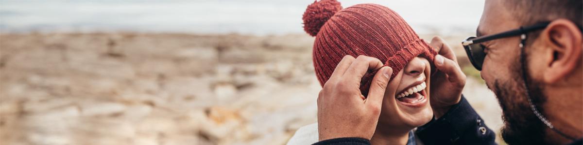 Man putting hat on woman.