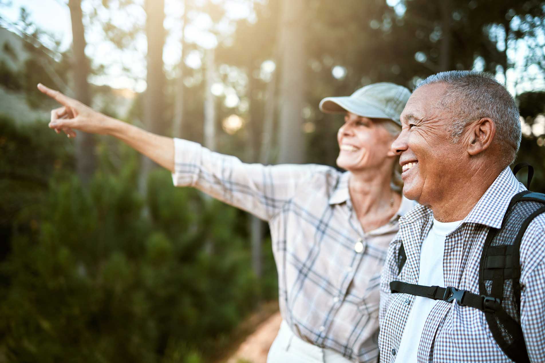 Senderismo, aventura y libertad con una pareja de ancianos que disfrutan y exploran el bosque o los bosques y comparten momentos juntos. Hombre y mujer jubilados felices, despreocupados y explorando, mirando las vistas al aire libre.