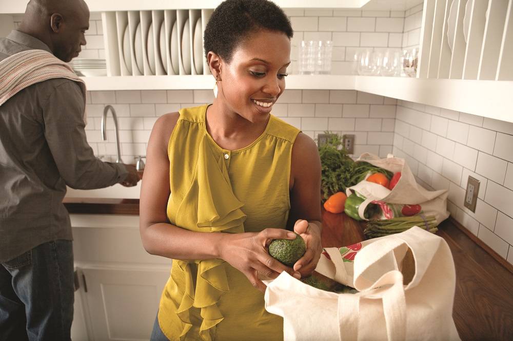 Couple putting groceries away in kitchen