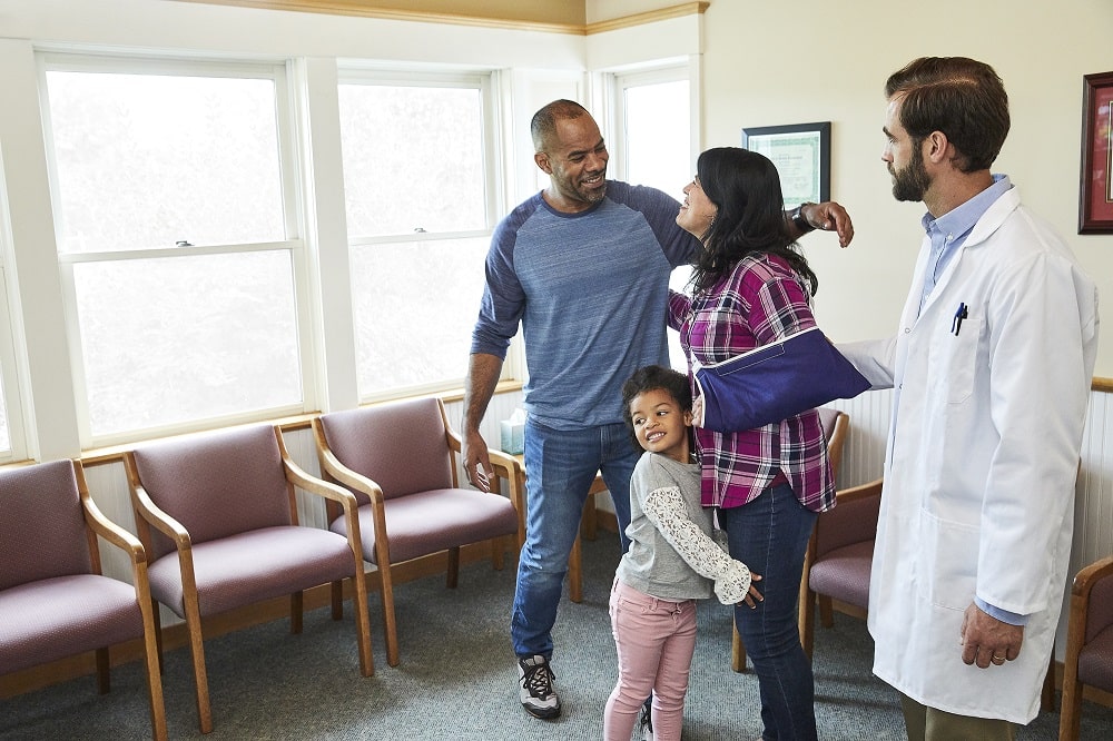 A happy family hugging in a patient waiting room