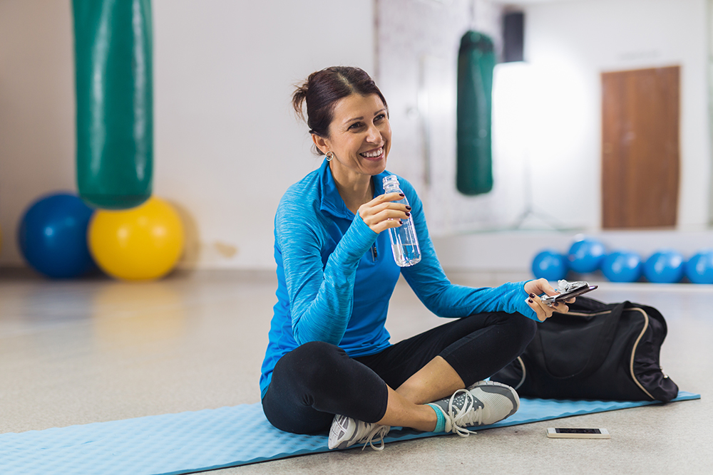 Woman smiling with workout gear on at the gym.