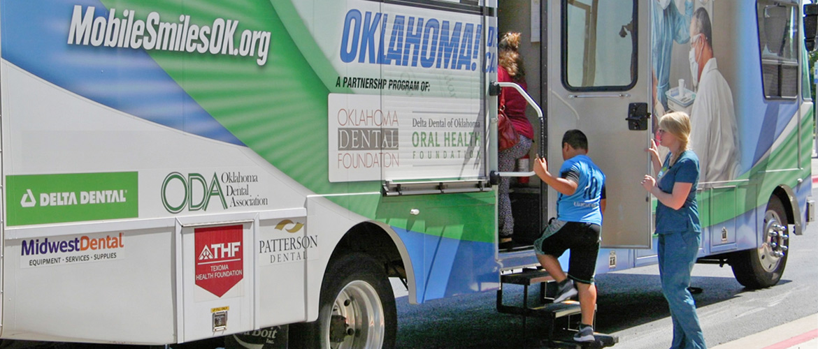 A child climbs on a dental health care van