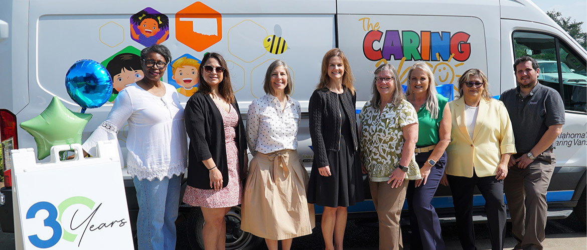 A group of people stand in front of a mobile clinic van