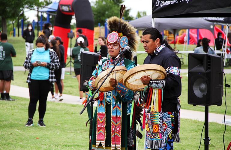 Native Americans in traditional dress perform at an event