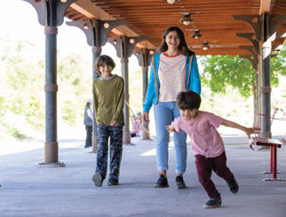 A family walking and a boy running with flying arms.